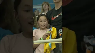 Summer McIntosh gives the medal she won in 200IM to a young fan