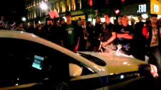 Protesters block access to a police car