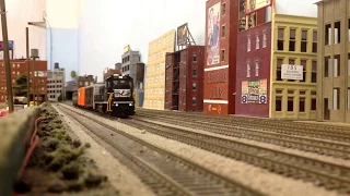 NS Genset #300 and reefer train pass the city landscape