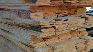 sah, wie geschickte Hände im Sägewerk dünne Holzbretter schnitten