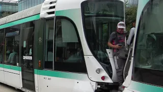 Paris T2 tramway - 2 guys standing on tram coupling of moving tram - danger - dont try this