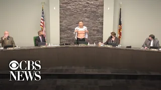 Asian American veteran lifts shirt at town meeting to reveal service scars while condemning anti-…