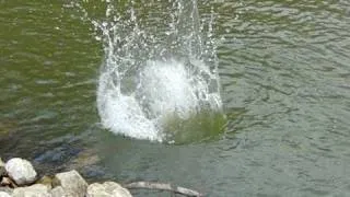 slow motion dropping a big rock into water!