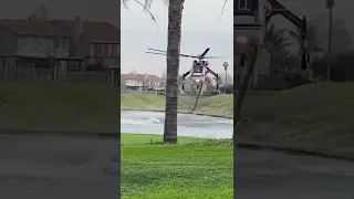 Helicóptero em voo reabastecendo de água do lago para apagar fogo