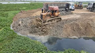 Incredible ! Bulldozers and Dump Trucks pushing rock into the lake Filling up big project