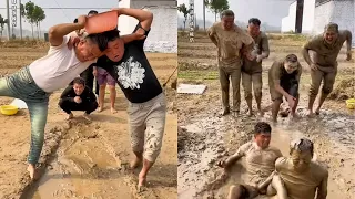 Carrying a basin of water over the mud pit challenge. Couple competition. Men's simple happiness. N