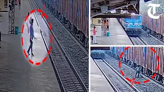 Watch daring act by a railway staff who saves man on the tracks seconds before train passes them by