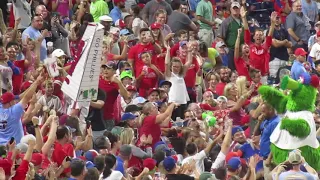 The Phillie Phanatic dumps popcorn on a Mets fan