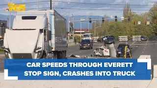 Car speeds through stop sign, crashes into semi-truck in Everett