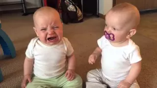 Twin baby girls fight over pacifier