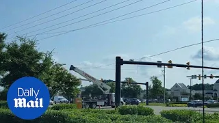 Truck with a crane takes out power lines and a traffic light