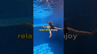 Girl swims underwater in pool