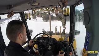 New Holland LB 115.B pushing snow - backhoe cab view