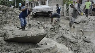 Venezuelans clean muddy streets after El Limon River overflowing | AFP