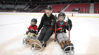 Brady Tkachuk sledge hockey with a young fan