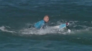 Surfing champ fights off shark attack on live TV.