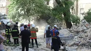 Спасатели вытаскивают из-под завалов автомобиль на улице Ясной в Одессе. 10 июня 2020 года.