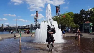 Darth Vader Stays Cool by Riding a Unicycle through a Fountain while Playing Bagpipes