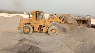 Old Cat 950 E-series wheel loader, filling the hopper on the truck loading plant, in a lime quarry