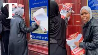 Women rip down posters in London showing kidnapped Israelis