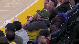 LeBron James falls into a fan courtside and hugs him right after