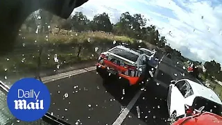 Terrifying moment a multi-truck crash almost wipes out highway police car