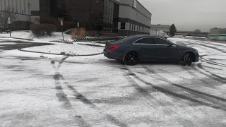 Mercedes CLS hits a curb while trying to drift in the snow