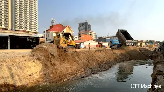 Updating Process Bulldozer & Trucks Pushing Rock And Sand Into Water Making Foundation Village Road