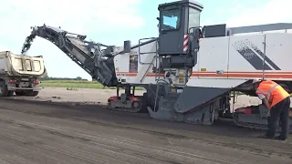 Crawler large road milling machine WIRTGEN W210i cuts the runway of Cherkasy airport