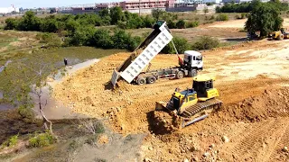 Update Processing skiller operator dozer spreading soil and Heavy dump truck unloading soil into mud