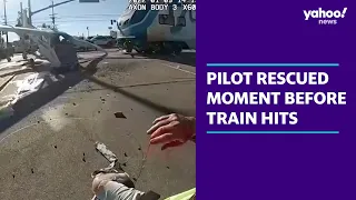 Moment pilot of crashed plane is rescued seconds before train hits | Yahoo Australia