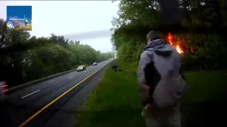 The video show the moment a stranger stopped to rescue a driver who was trapped in a burning vehicle