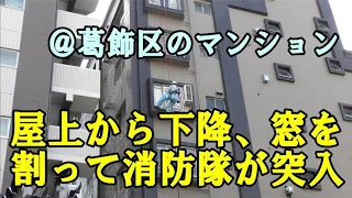 屋上から下降した消防隊員がガラスを割って部屋に突入する迫力シーン