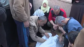 Distraught relatives pray for victims of air strikes as they collect remains from Khan Younis morgue