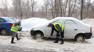 Дворники тщательно убирают снег во дворе дома