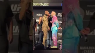 kamaru usman pushes colby Covington at the face of