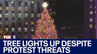 Rockefeller Christmas Tree lights up despite protest threats