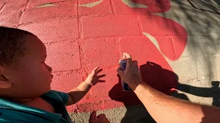 Baby Helps Paint Graffiti Letters on Childrens Park