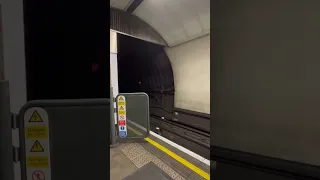 EXTREME SPEED, London underground train approaches platform at high speed.