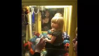 Little girl in a ball claw machine