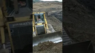 KOMATSU Powerful bulldozer leveling dirt road at coal mine.