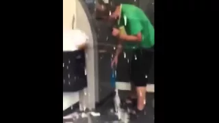 A drunk man with his beer, trying to withdraw money at an ATM