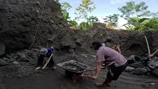 Dig up the black sand around the big rocks, before the dump truck comes