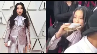 awkwafina takes a swig of tequila from guillermo at 2019 Oscar Red Carpet