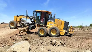 Motor Grader John Deere 670G pushing material working on the Vía Central project, a train for UPM