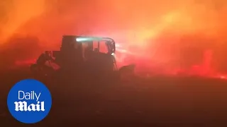 Firefighters use bulldozers to fight fires in extreme winds