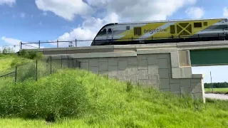 125mph Brightline flies over Dallas Blvd. Fastest train in Florida.