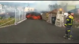 Firefighters look on as lava flows incinerate structures on La Palma, Spain