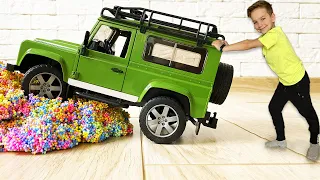 Mark rides slime and kinetic sand obstacles in cars with big wheels