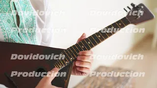 Russian boy in national dress plays the balalaika. Close-up of a balalaika.